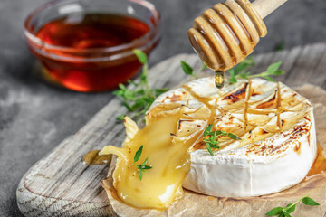 Delicious beautiful baked camembert with honey, walnuts, herbs