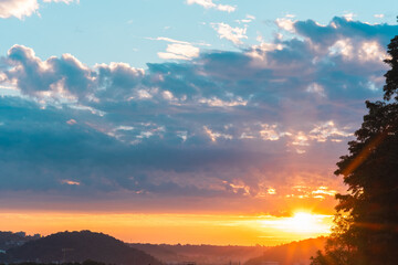 Bright sunrise shines over the beautiful landscape horizon