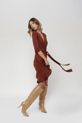 Serie of studio photos of young female model in brown viscose casual wrap dress