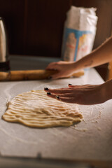 hands rolling the dough on the table