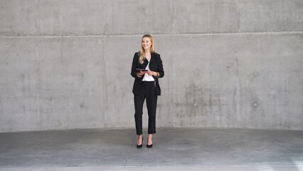 Confident Businesswoman Standing with Tablet in Modern Office