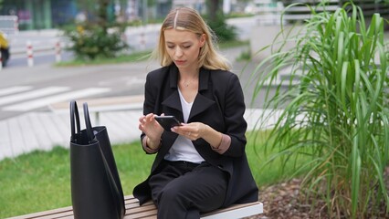 Professional Woman Checking Phone on City Bench