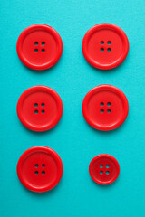 Six red cloth buttons on a blue table - 770589603