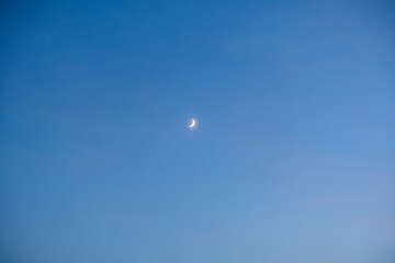 waxing crescent moon on the blue sky