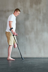Physical therapy, patient with disability or amputee walking with crutches at clinic for recovery,...