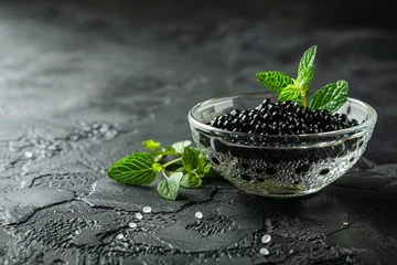 Foto op Plexiglas A luxurious glass bowl of black caviar garnished with fresh herbs © Creative_Bringer