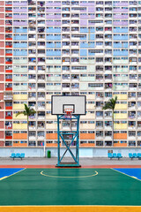 Colorful rainbow pastel building with basketball court and facade windows background in public park. Architecture building design in Choi Hung Estate, Kowloon, Hong Kong City, China.