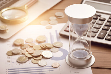 Coins, hourglasses, and other office supplies placed on financial data charts