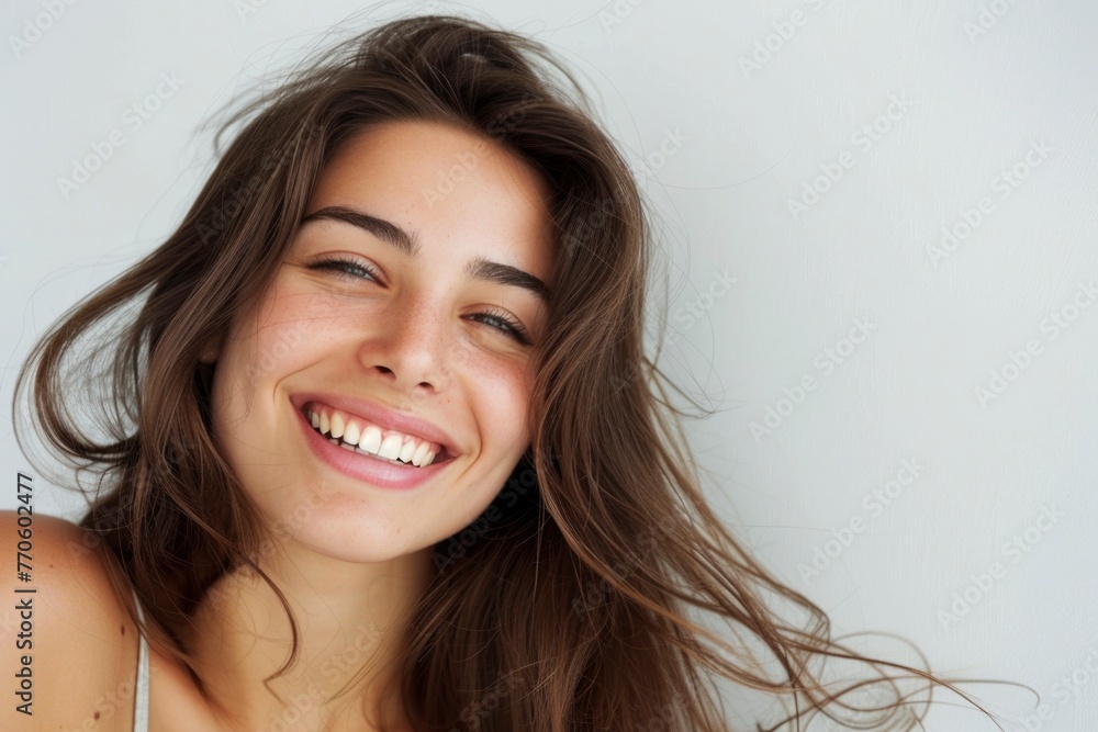 Wall mural Effervescent beauty with a sun-kissed smile and flowing brown hair, light-hearted in a subtle grey top