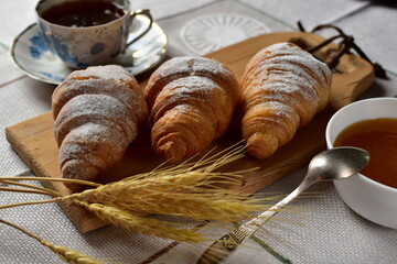 croissant , jam and tea on a table