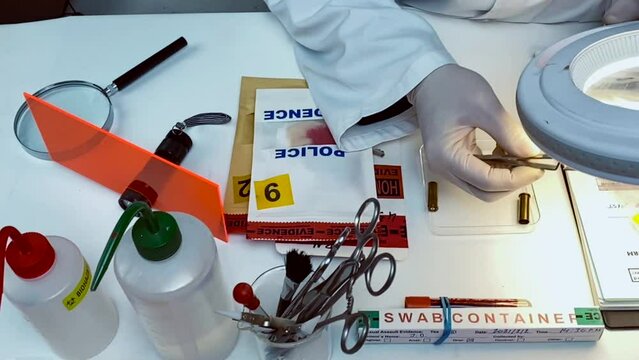 Scientific police examining a bullet cap in ballistic Laboratory, conceptual ivideo	