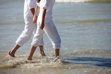 Walking, beach and legs of couple holding hands for summer holiday, vacation and weekend by ocean....
