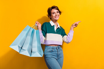 Photo of cheerful positive lady dressed polo shirt rising shoppers pointing empty space isolated...