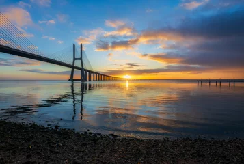Foto op Plexiglas Vasco da Gamabrug Vasco da Gama bridge and pier over tagus river in Lisbon (Portugal), at sunrise