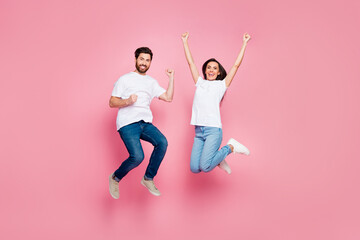 Full body photo of nice young couple jump raise fists celebrate wear trendy white outfit isolated...