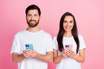 Photo portrait of nice young couple hold gadgets ecommerce promo wear trendy white outfit isolated on pink color background