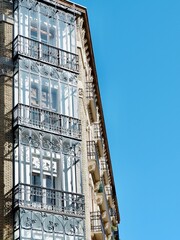 Rich vintage balconies made of wrought metal backlit by sun in Zaragoza, Spain vertical photo