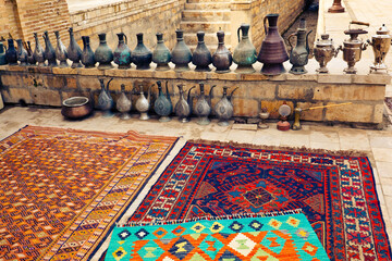 Gifts of Bukhara - beautiful Uzbek carpets and old copper jugs - obrazy, fototapety, plakaty