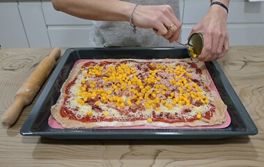 Making pizza, adding corn