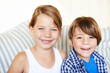 Portrait, smile and children on sofa in home for bonding, love and family relax together on couch in living room. Face, kids and happy siblings in lounge, brother and adorable young sister in house