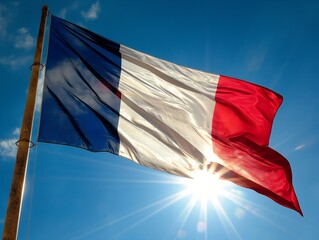 A large French flag is flying in the sky on a sunny day. The flag is red, white, and blue, and it is waving in the wind