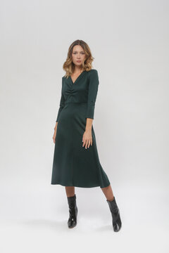 Serie of studio photos of young female model wearing green dress