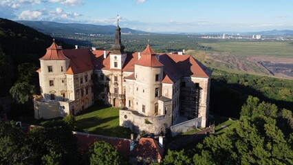 Aerial view of majestic Jezeri castle is perched atop a hill surrounded by a lush forest of trees