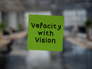 Post note on glass with 'Velocity with Vision'.