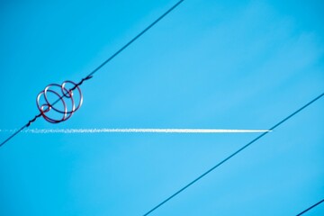 Low angle of an airplane track seen through metal wires