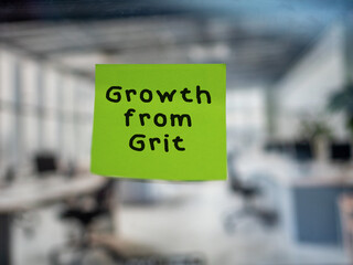 Post note on glass with 'Growth from Grit'.