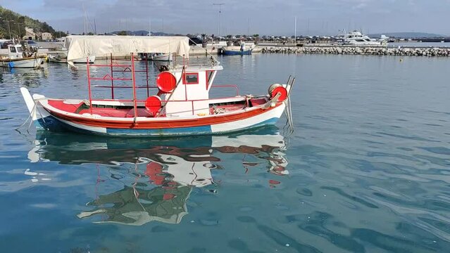 Small white and red boat parked on the sea port on a sunny day