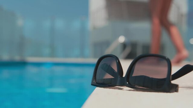Sunglasses beach summer vacation background. Beach pool equipment with travel sunglasses on yellow holiday towel. Tropical vacation concept.