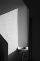 Interior shot of a black and white wall with a vintage chair illuminated by natural light