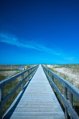 Fototapeta premium Vertical of a wooden boardwalk on the beach