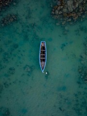 Aerial top view of a sailboat in a turquoise sea