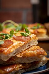 Array of freshly prepared pizza slices, adorned with green toppings, on a plate