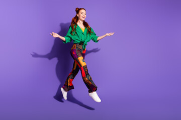 Fototapeta na wymiar Full length photo optimistic girl wear print trousers vintage shirt flying arms presenting objects isolated on violet color background