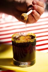 Closeup of a vibrant  fresh cocktail on a surface with a colorful background - obrazy, fototapety, plakaty