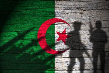 Algeria flag on wood and soldiers shadow - obrazy, fototapety, plakaty