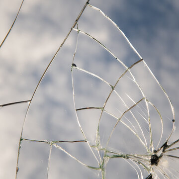background with broken cracked mirror glass pieces reflecting the blue sky with clouds