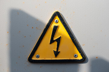Danger electrical hazard high voltage sign, black triangle with yellow color.