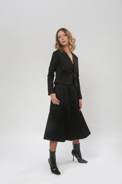 Serie of studio photos of female model wearing black blazer and black midi dress