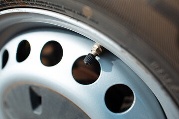 Close-up of tire valve cap on car tire.