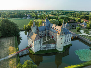 Aerial view of Kasteel van Laarne with lush garden and moat in sunset, Laarne, East Flanders, Belgium.