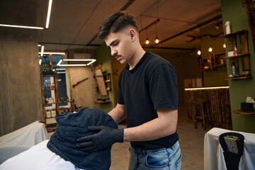 Fototapeta premium Bearded man getting shaved with straight edge razor by hairdresser
