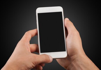 Human hand holding modern smartphone with blank screen.