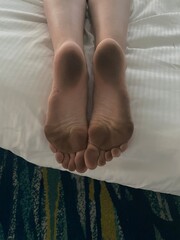 dirty feet on white clean bed