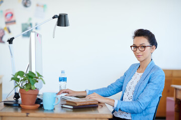 Computer, office and portrait of business woman with confidence, company pride and glasses at desk. Professional, startup and face of person in workplace for career, job opportunity and working