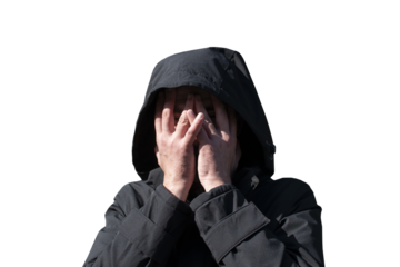 A man in a hood covering his face with his hands