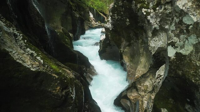 Drone footage of the glacier water of Soca River flowing through a rocky canyon, Slovenia